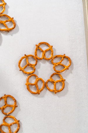 Dipping pretzels twists into melted chocolate to make a chocolate pretzel Christmas wreath.の写真素材