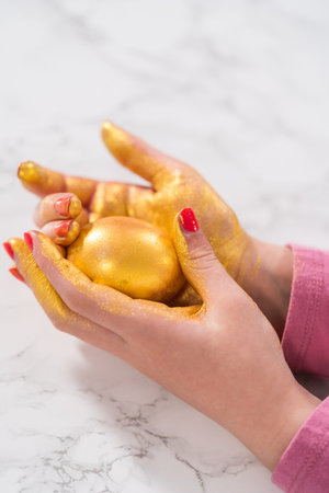 Easter egg coloring. Painting Easter eggs with gold luster.の写真素材
