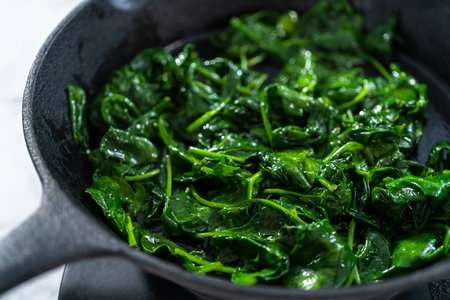 Sauteeing spinach for spinach and ham frittata.の写真素材