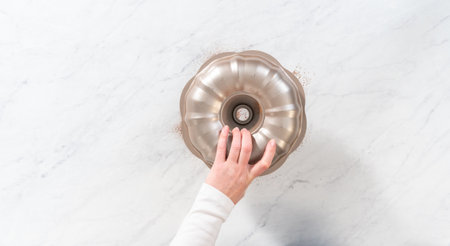 Flat lay. Greasing metal bundt cake pan with vegetable shortening and cocoa powder to bake gingerbread bundt cake with caramel filling.の写真素材