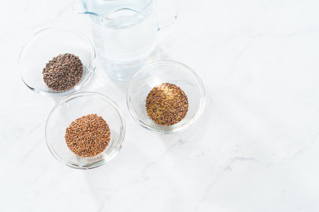 Day 1. Variety of seeds in a small glass bowl for growing sprouts in a jar.の写真素材