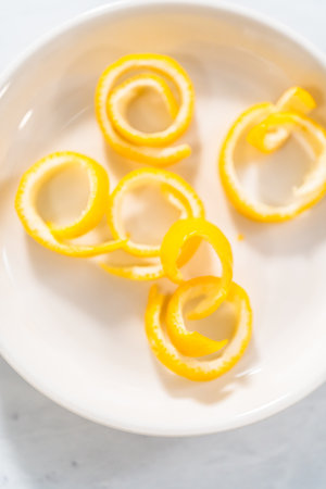 Preparing lemon swirls from the organic lemon to decorate the cocktail.の写真素材