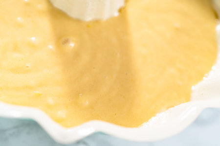 Lemon pound cake batter in a baking bundt pan ready to be baked.