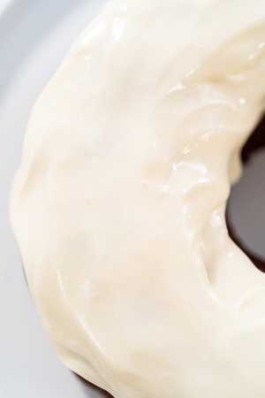 Pouring cream cheese glaze over freshly baked red velvet bundt cake.の写真素材