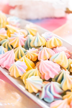Multicolored unicorn meringue cookies on a white serving plate.の写真素材