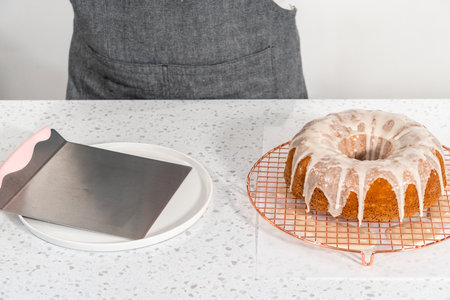 Glazing vanilla bundt cake with a white vanilla glaze.の写真素材