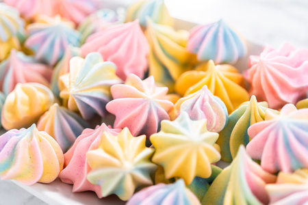 Multicolored unicorn meringue cookies on a white serving plate.の写真素材