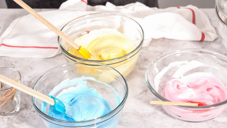 Step by step. Mixing in food coloring into the meringue to bake unicorn meringue pops cookies.