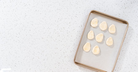 Flat lay. Rolling bread dough with a french rolling pin to bake naan dippers.の写真素材