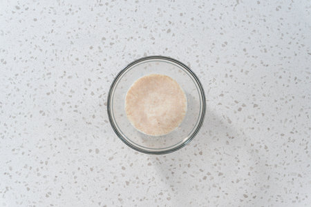 Flat lay. Activating dry yeast in a glass mixing bowl to bake naan dippers.の写真素材