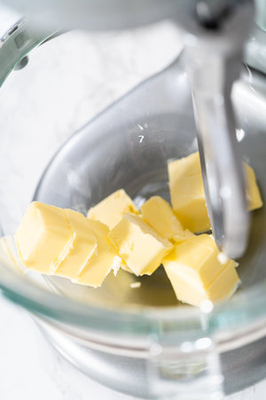 Mixing ingredients in kitchen electric mixer to make lemon buttercream frosting.の写真素材