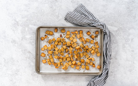 Flat lay. Cooling freshly dried croutons on a baking sheet lined with parchment paper.の写真素材