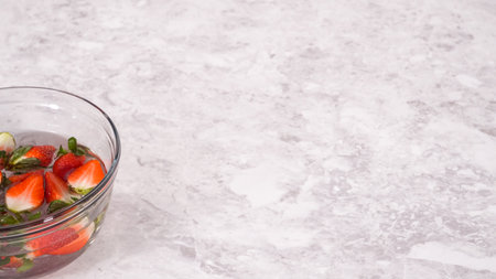 Step by step. Washing organic strawberries in a bowl with water.の写真素材