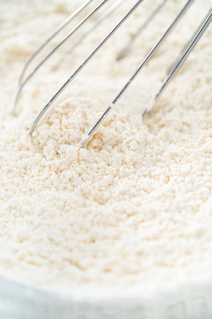Close up view. Close up view. Mixing ingredients in a glass mixing bowl to bake funfettti bundt cake.の写真素材