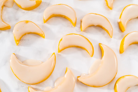 Lemon wedge cookies with lemon glaze. Dipping lemon cookies into a lemon glaze.の写真素材
