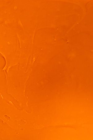 Pouring fudge mixture into the square glass baking pan lined with parchment paper to prepare candy corn fudge.の写真素材