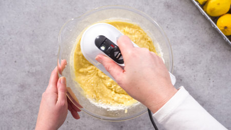 Flat lay. Step by step. Mixing ingredients in a glass mixing bowl to prepare lemon cranberry bundt...