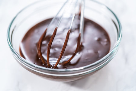 Preparing chocolate ganache in a glass mixing bowl.の写真素材
