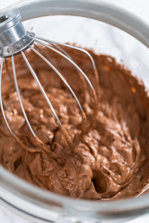 Whipping chocolate ganache with an electric kitchen mixer.
