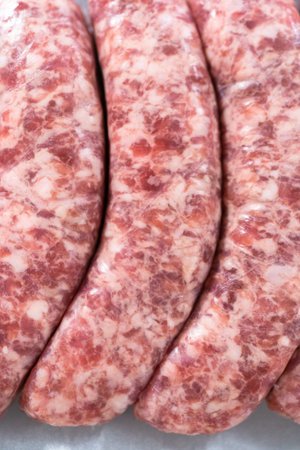 Raw beer bratwursts in the row on a small tray.