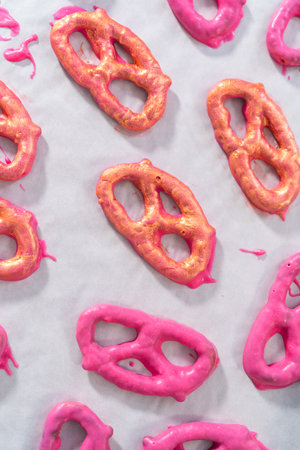 Painting chocolate-covered pretzel twists with glittery luster.の写真素材