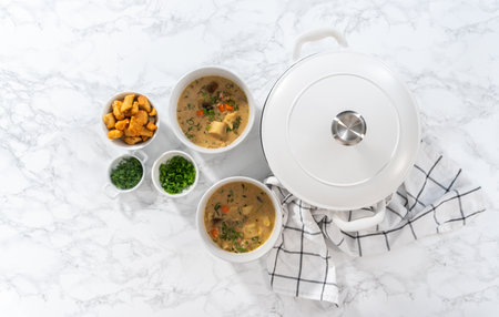 Flat lay. Serving creamy wild mushroom soup made out of dehydrated wild mushrooms in white bowls with sourdough bread.の写真素材