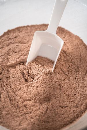 Mixing ingredients in a large glass mixing bowl to bake homemade hot chocolate mix.の写真素材