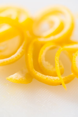 Preparing lemon swirls from the organic lemon to decorate the cocktail.の写真素材