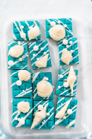 Packaging mini mermaid chocolate bars into a food glass container for storage.の写真素材