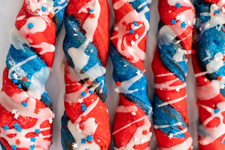 Patriotic cinnamon twists drizzled with a white glaze and decorated with star sprinkles.の写真素材