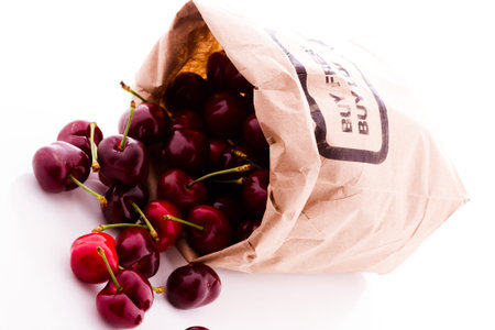 Brown bag of fresh cherries from the local farmers market.