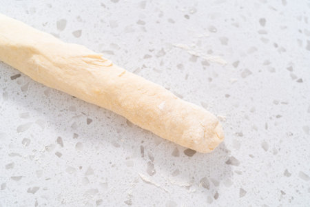 Rolling bread dough with a french rolling pin to bake naan dippers.