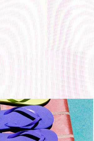 Colorful flip flops by a swimming pool.