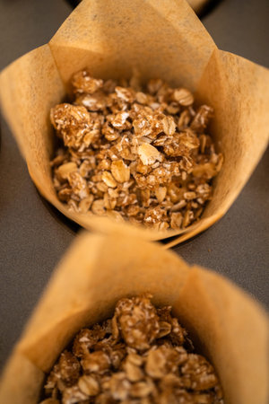 Scooping dough with dough scoop into cupcake pan lined with tulip paper muffin liners to bake banana...