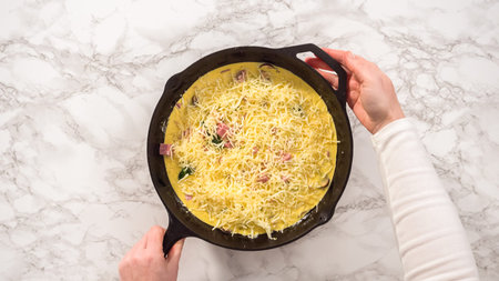 Flat lay. Step by step. Preparing spinach and ham frittata in cast iron skillet.