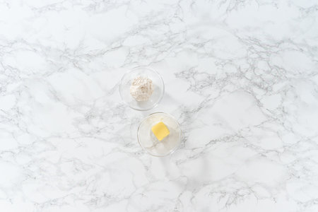 Flat lay. Measured ingredients in a glass mixing bowl to greased baking pan for baking.の写真素材