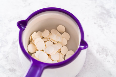 Melting chocolate chips in a candy melting pot to make mermaid pretzel twists.の写真素材