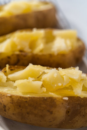 Pressure Cooker Baked Potatoes. Sliced cooked whole potatoes on a white plate to make baked potatoes.の写真素材