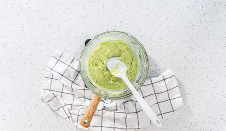 Flat lay. Melting chocolate chips and other ingredients in a glass mixing bowl over boiling water to prepare pistachio fudgの写真素材