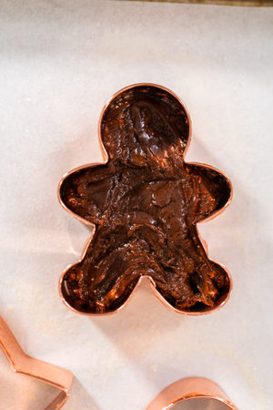 Filling cookie cutter with fudge mixture to prepare Christmas cookie-cutter peppermint fudge.