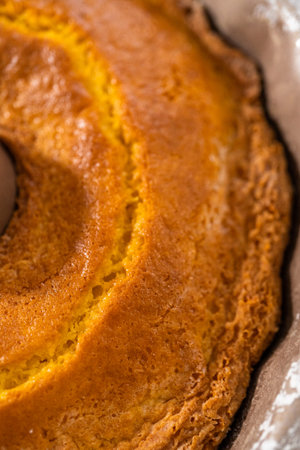 Cooling freshly baked simple vanilla bundt cake on a kitchen counter.