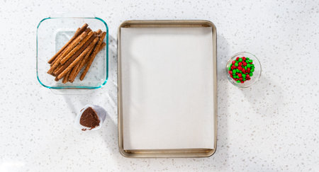 Denver, Colorado, USA-December 18, 2022-Flat lay. Dipping pretzel rods into melted chocolate and sprinkling candies to make chocolate-covered pretzel rods.のeditorial素材