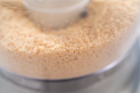 Crumbling stale bread in a food processor to make bread crumbs.の写真素材