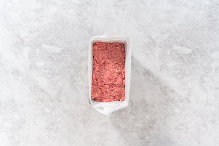 Flat lay. Preparing classic meatloaf in a loaf pan lined with parchment paper.の写真素材