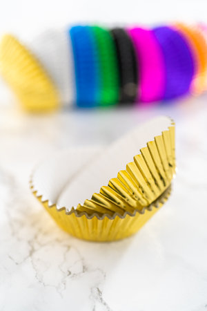 New foil cupcake liners of different colors on the kitchen counter.の写真素材