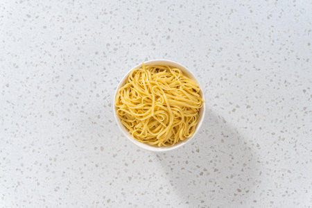 Flat lay. Large bowl with linguine pasta on a kitchen counter.の写真素材