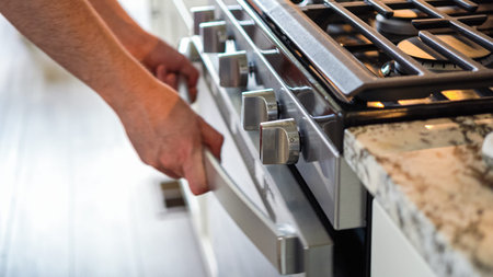 Within the setting of a modern kitchen, a young man is immersed in preparing dinner, currently...