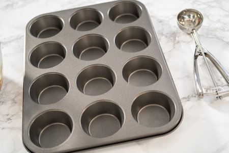 Lining cupcake pan with foil cupcake liners to bake gingerbread cupcakes.