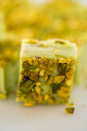 Homemade pistachio fudge pieces on a white cutting board.の写真素材
