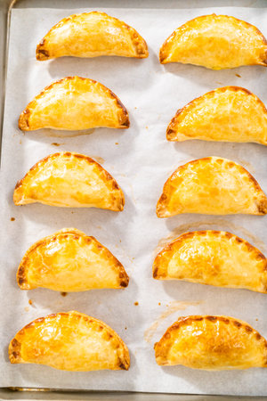 Freshly baked breakfast empanadas with eggs and sweet potato on the kitchen counter.